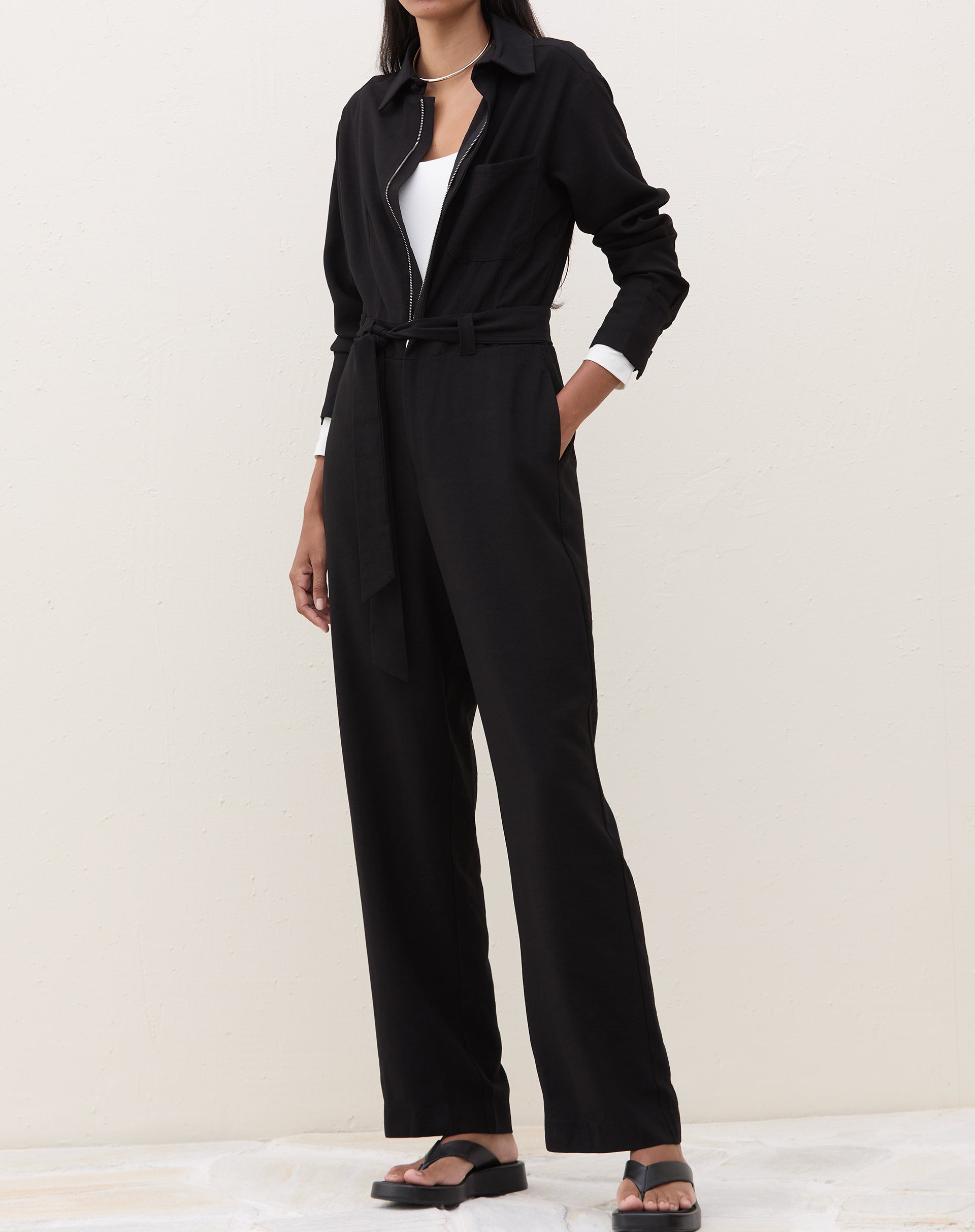 Look completo com o body em off-white combinado com macacão preto.