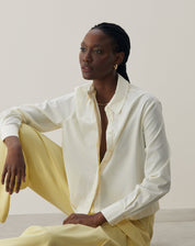 Vista sentada da camisa básica curta em amarelo claro, destacando o conforto.