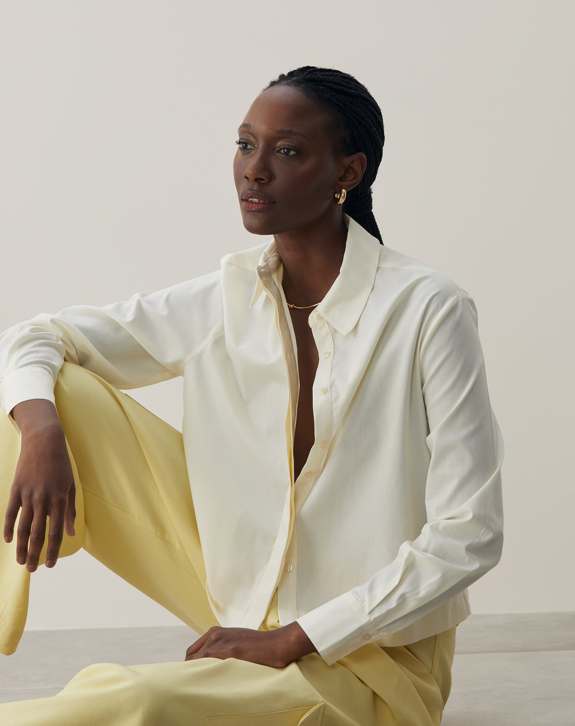 Vista sentada da camisa básica curta em amarelo claro, destacando o conforto.