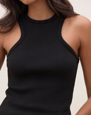 Detalhe do decote halter da blusa preta de tricô.