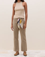 Modelo vestindo a blusa de tricô caqui com calça e lenço.