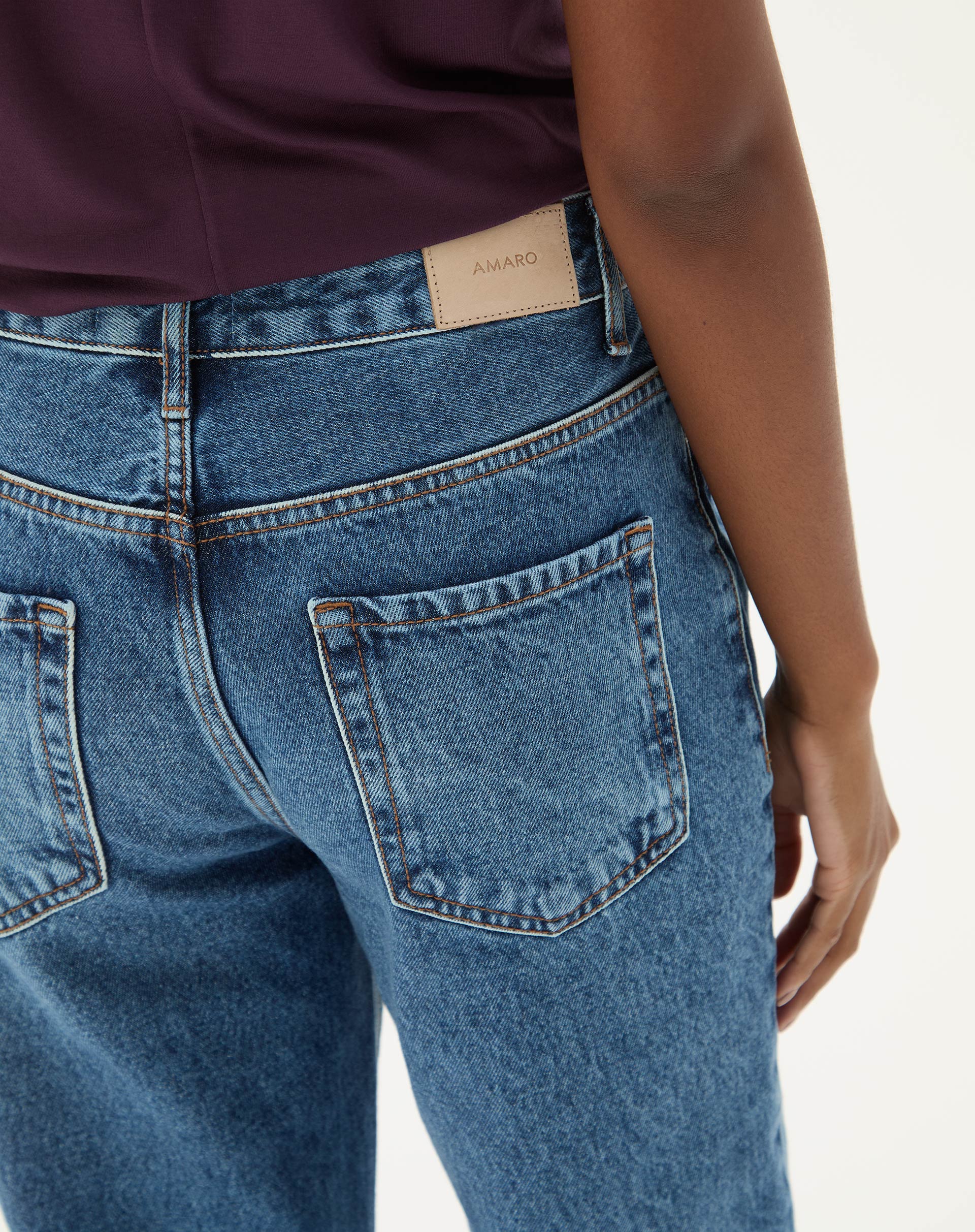 Detalhe do bolso traseiro da calça jeans azul médio.