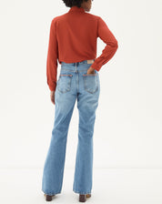 Vista traseira da calça jeans flare azul claro.