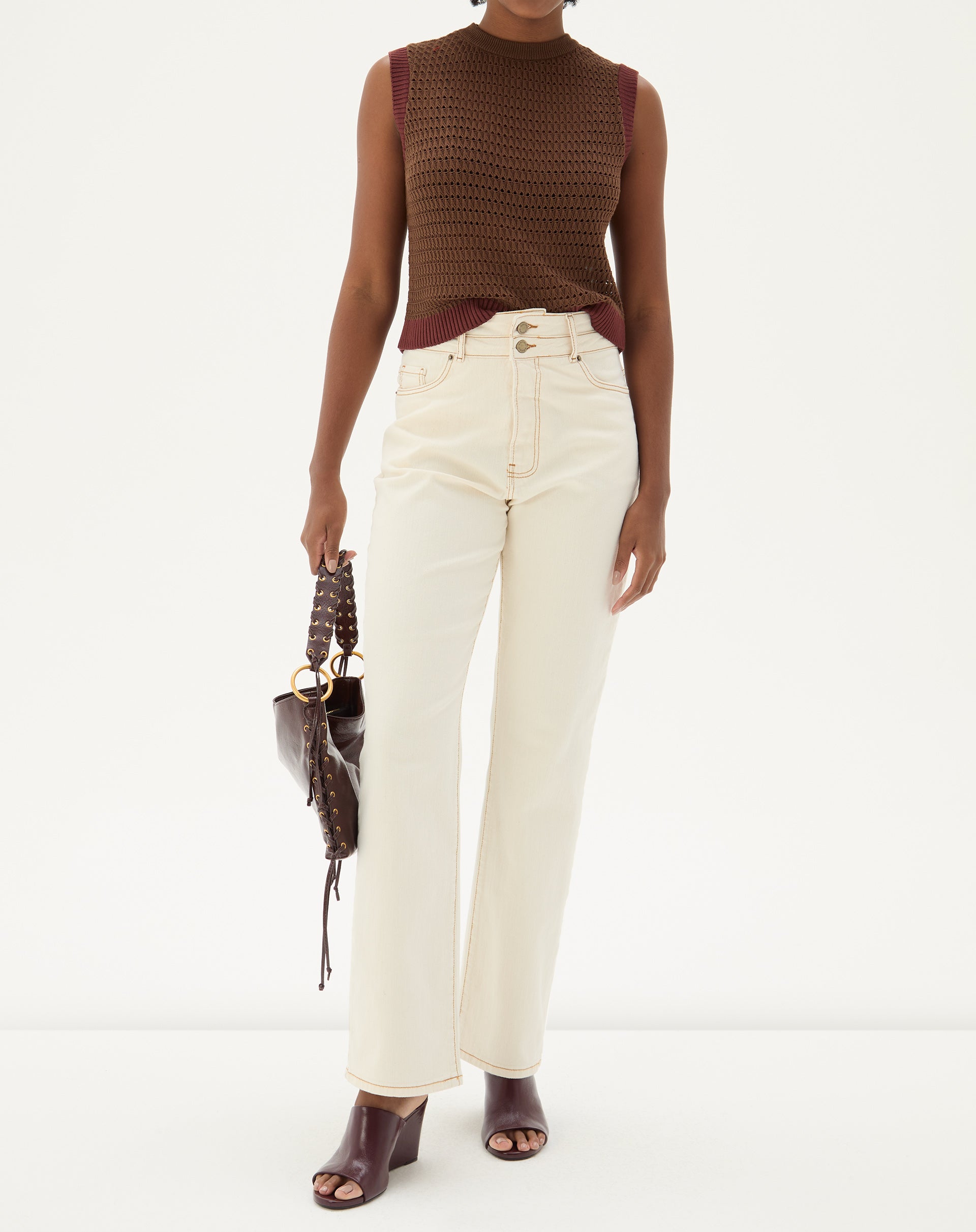 Calça reta de cintura alta em sarja bege, vista de frente, com detalhes de bolsos e fechamento por botão.