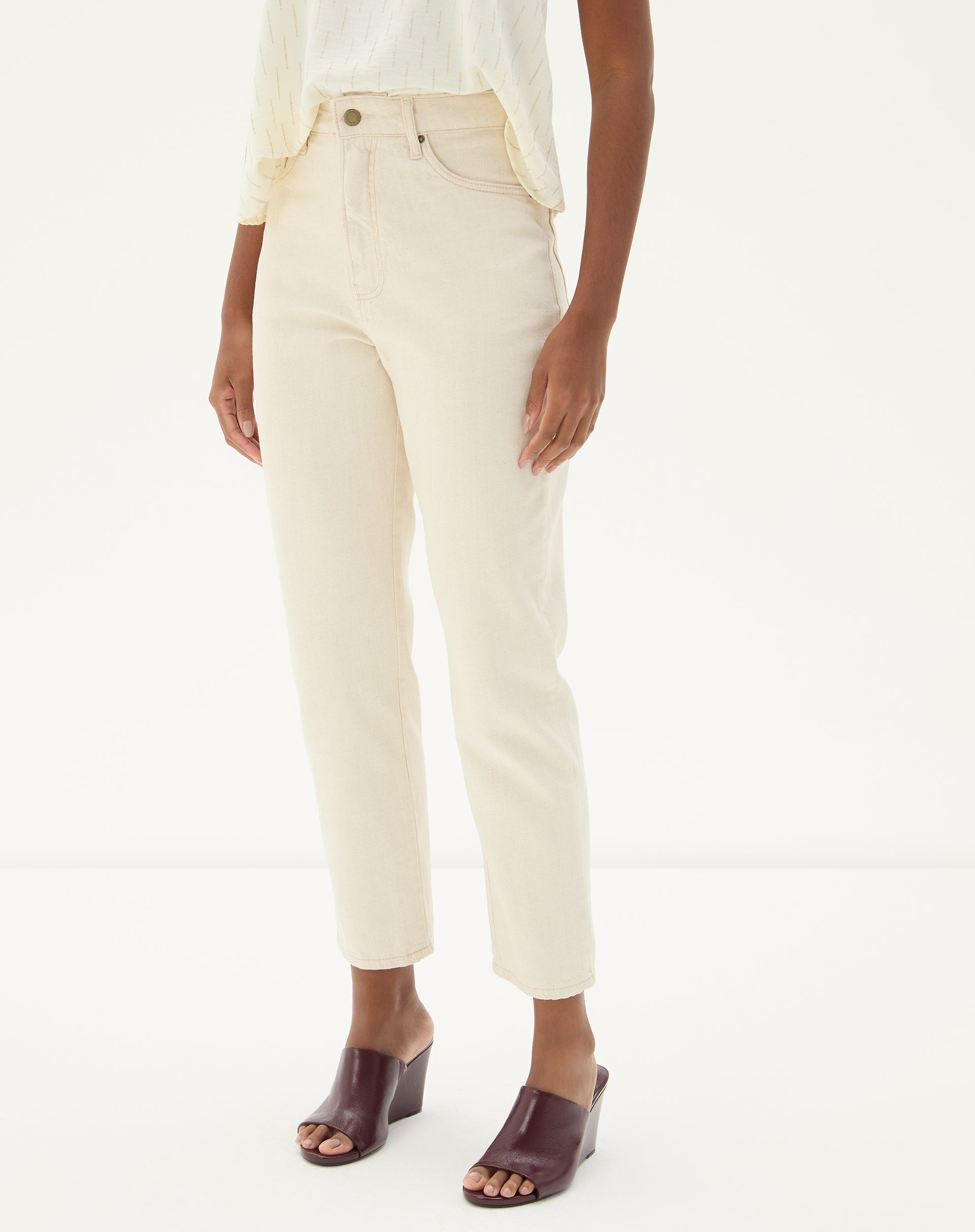 Vista frontal da calça bege com ajuste slim e cós médio.