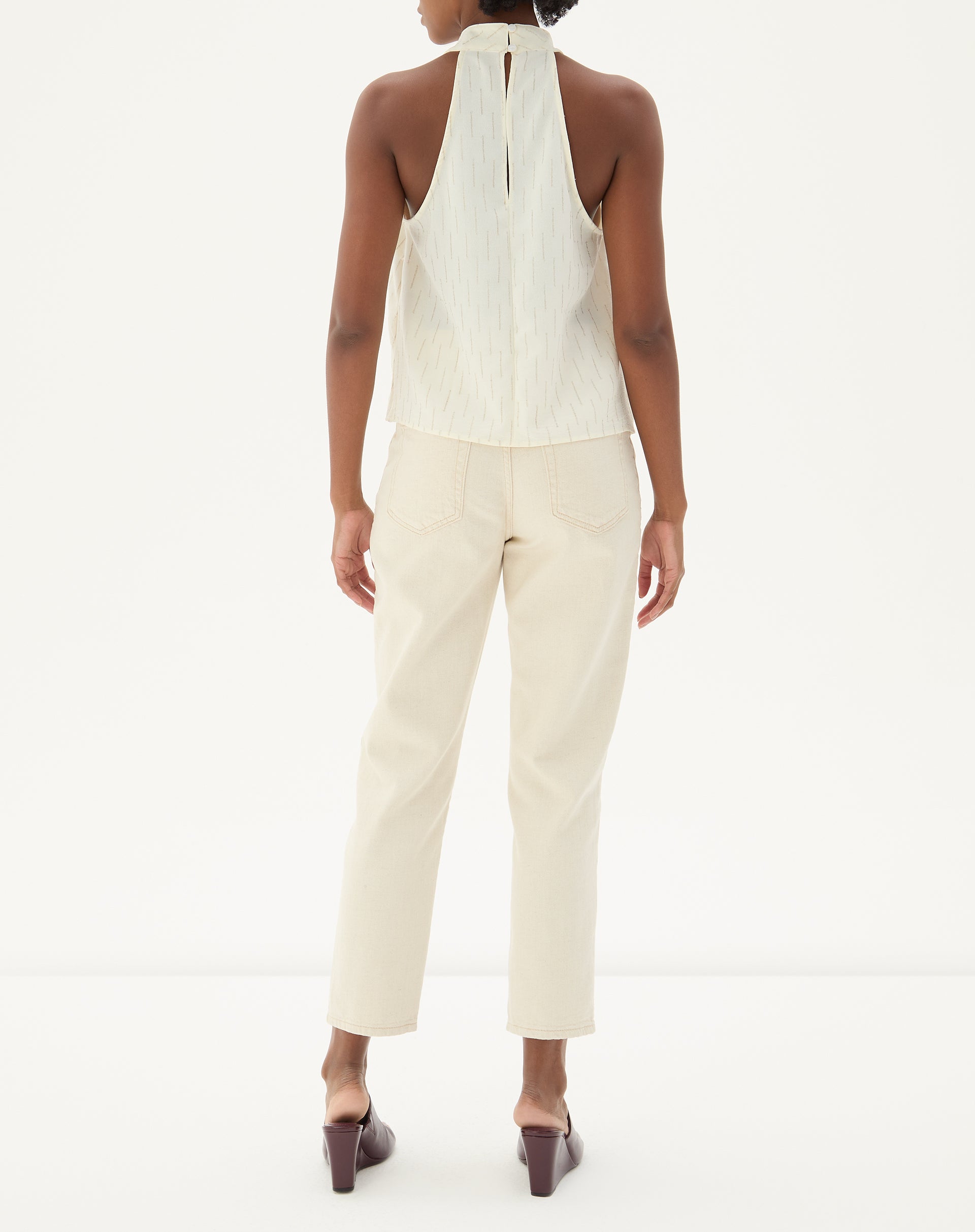 Vista traseira da calça bege mostrando os bolsos e ajuste reto.