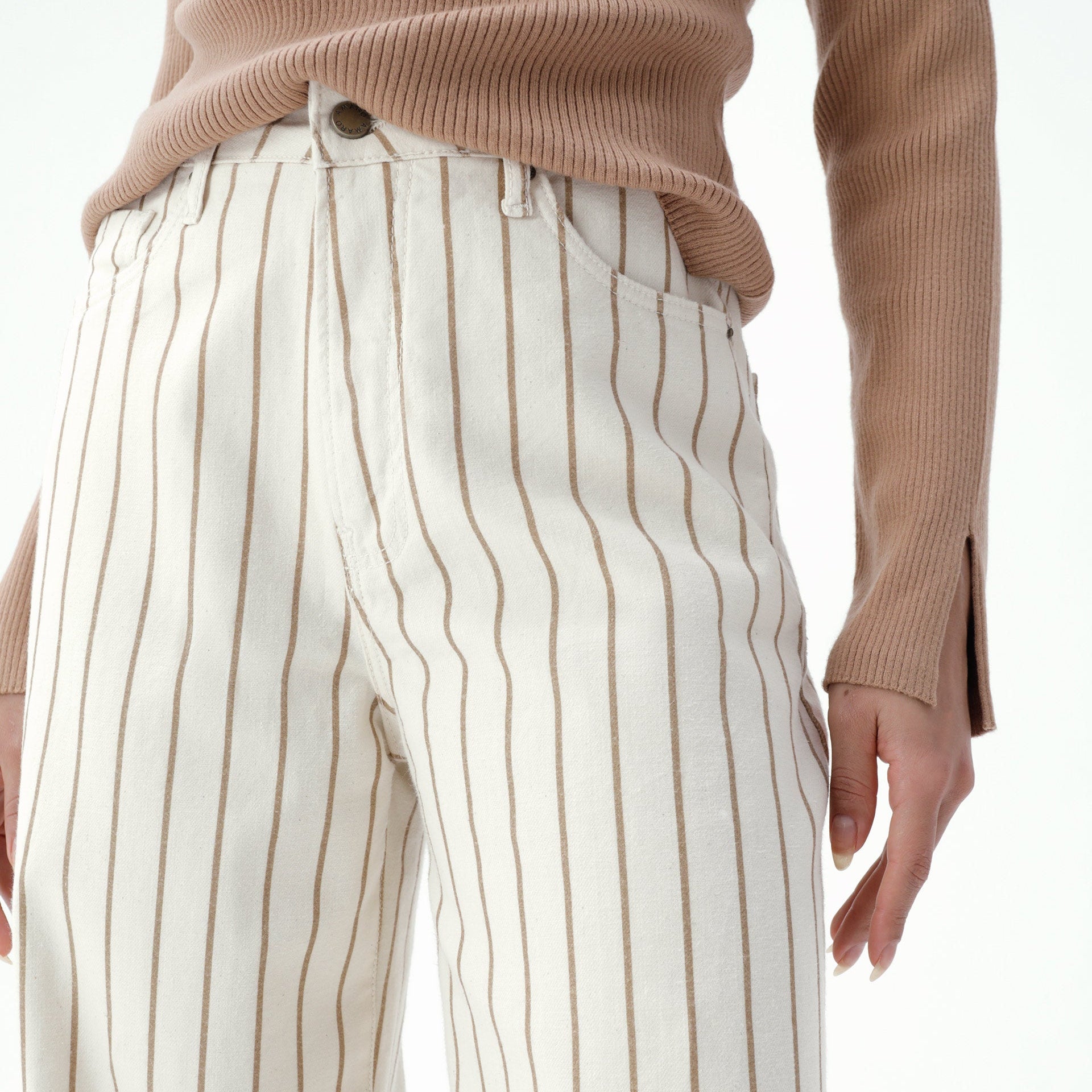 Detalhe da cintura da calça wide leg sarja bege com estampa listrada.