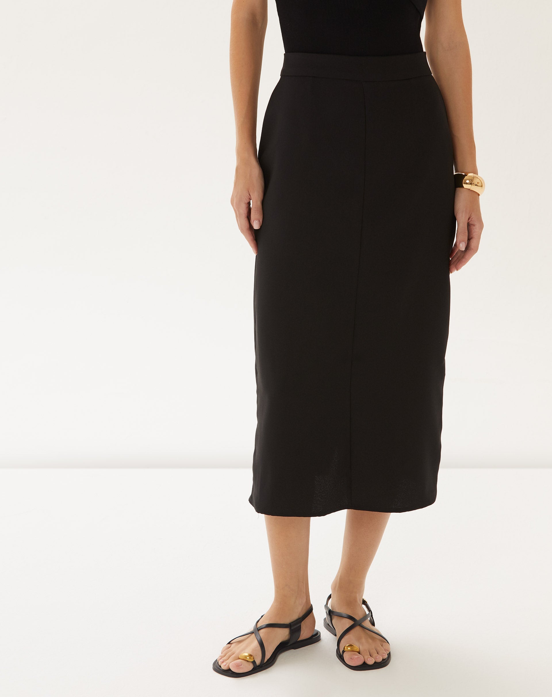 Vista frontal da saia midi preta em modelo.