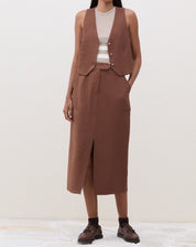 Modelo vestindo a regata com saia marrom.