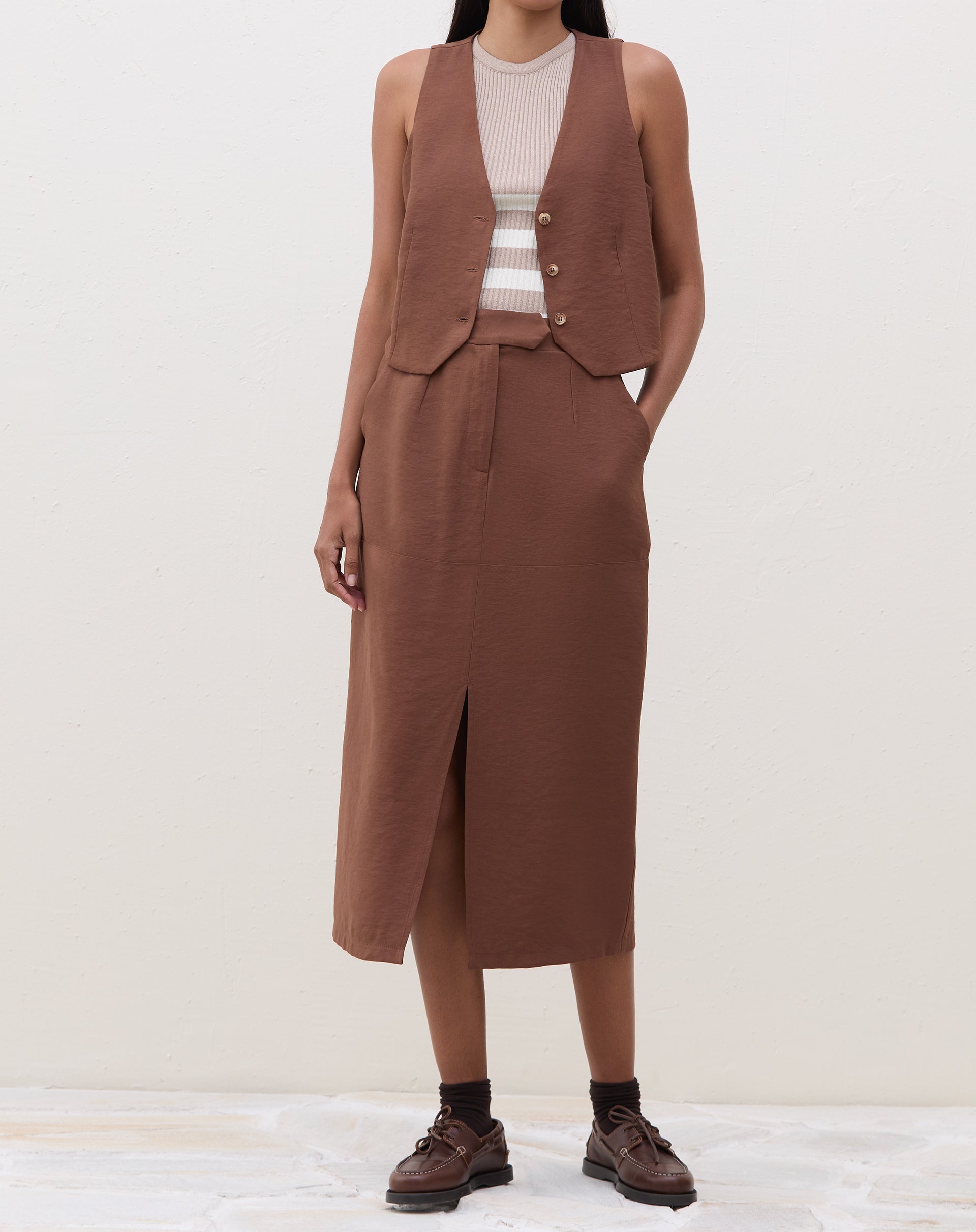 Modelo vestindo a regata com saia marrom.