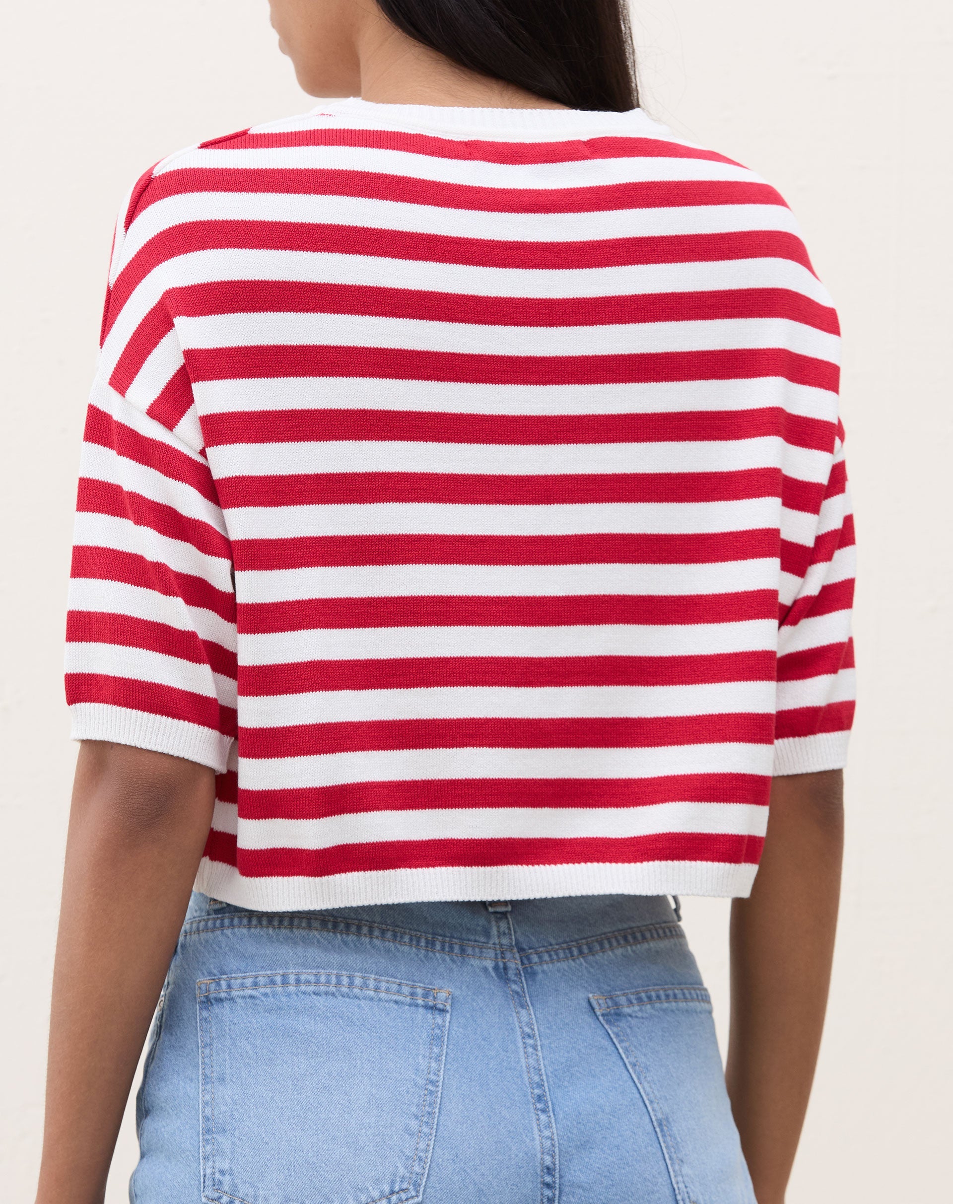 Camiseta cropped de tricot listrada em vermelho e branco, vista traseira.