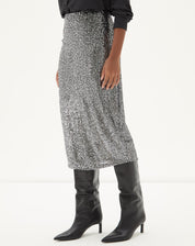 Vista lateral da Saia Midi Tubo de Paetê - Prata com camisa preta e botas pretas.