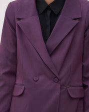 Close-up do blazer roxo mostrando os bolsos com aba e botões.