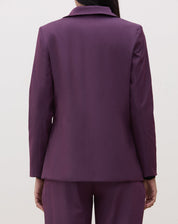 Vista traseira do blazer roxo mostrando o corte estruturado.