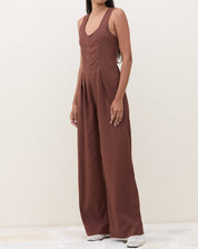 Imagem de um macacão marrom com pregas, visto de frente.