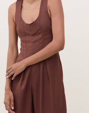 Imagem de um macacão marrom com pregas, mostrando detalhes do decote.