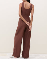 Imagem de um macacão marrom com pregas, visto de costas.