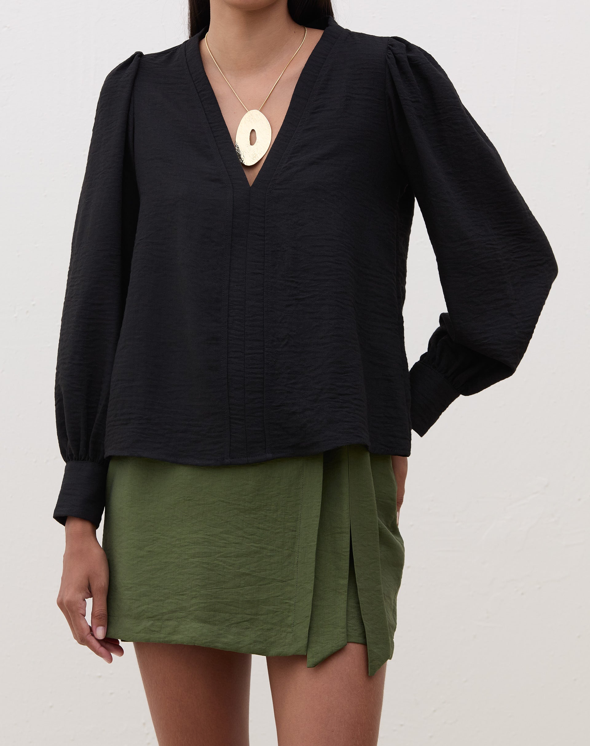 Blusa preta com manga longa e decote V, vista frontal.