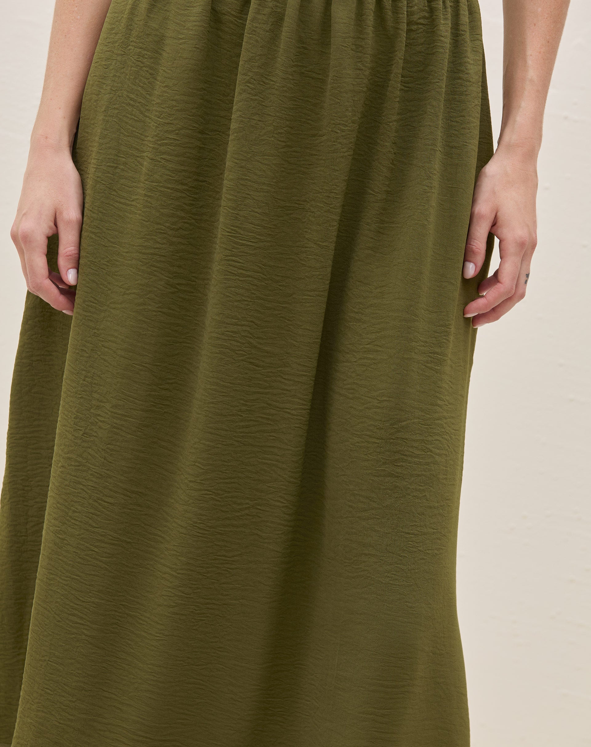 Detalhe da textura do tecido da saia midi verde militar.