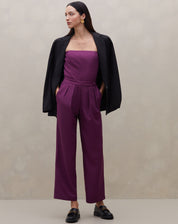 Modelo vestindo calça reta roxa com cós transpassado e blazer preto, mostrando um look elegante.