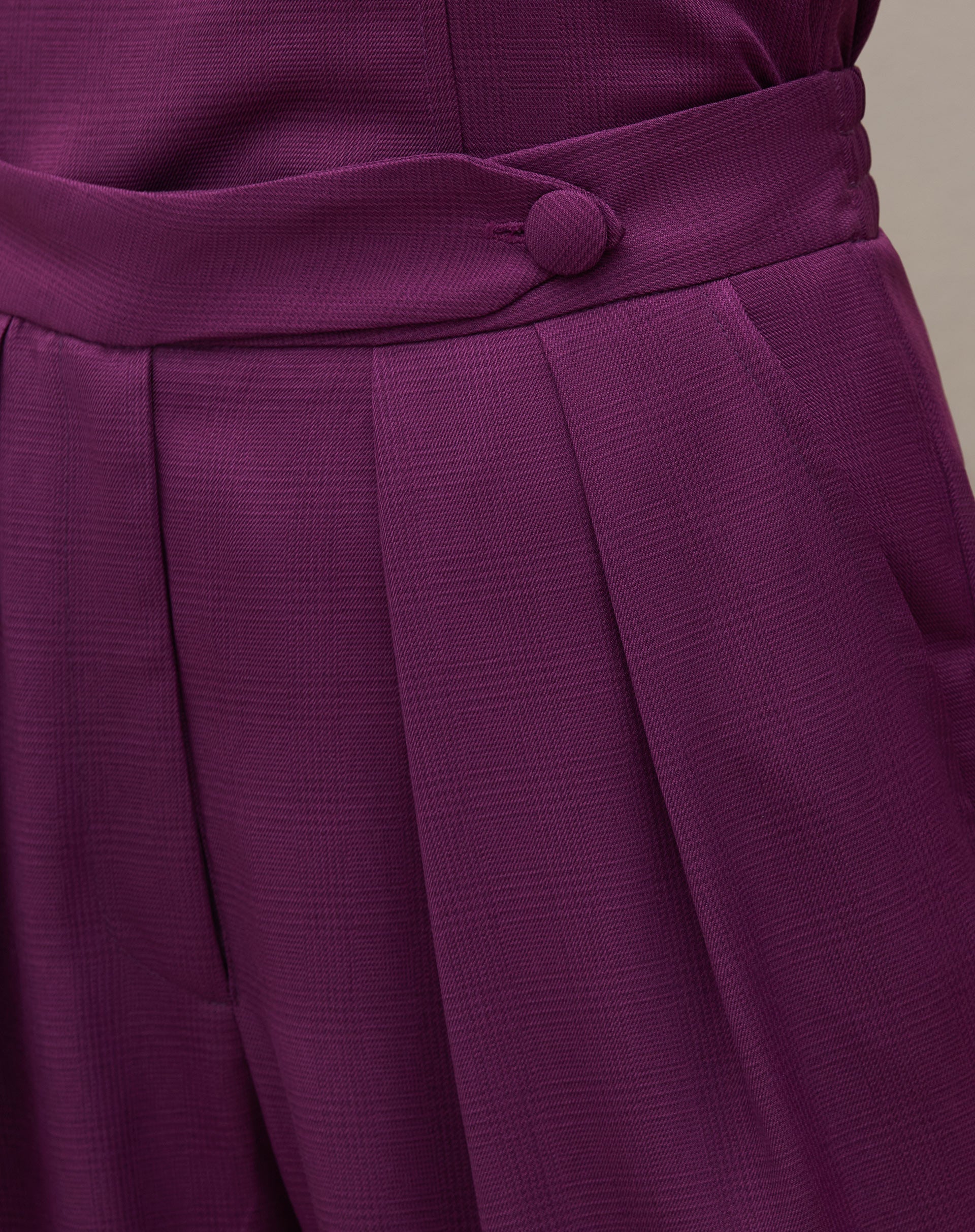 Vista traseira da calça reta roxa com cós transpassado, mostrando o ajuste e caimento.