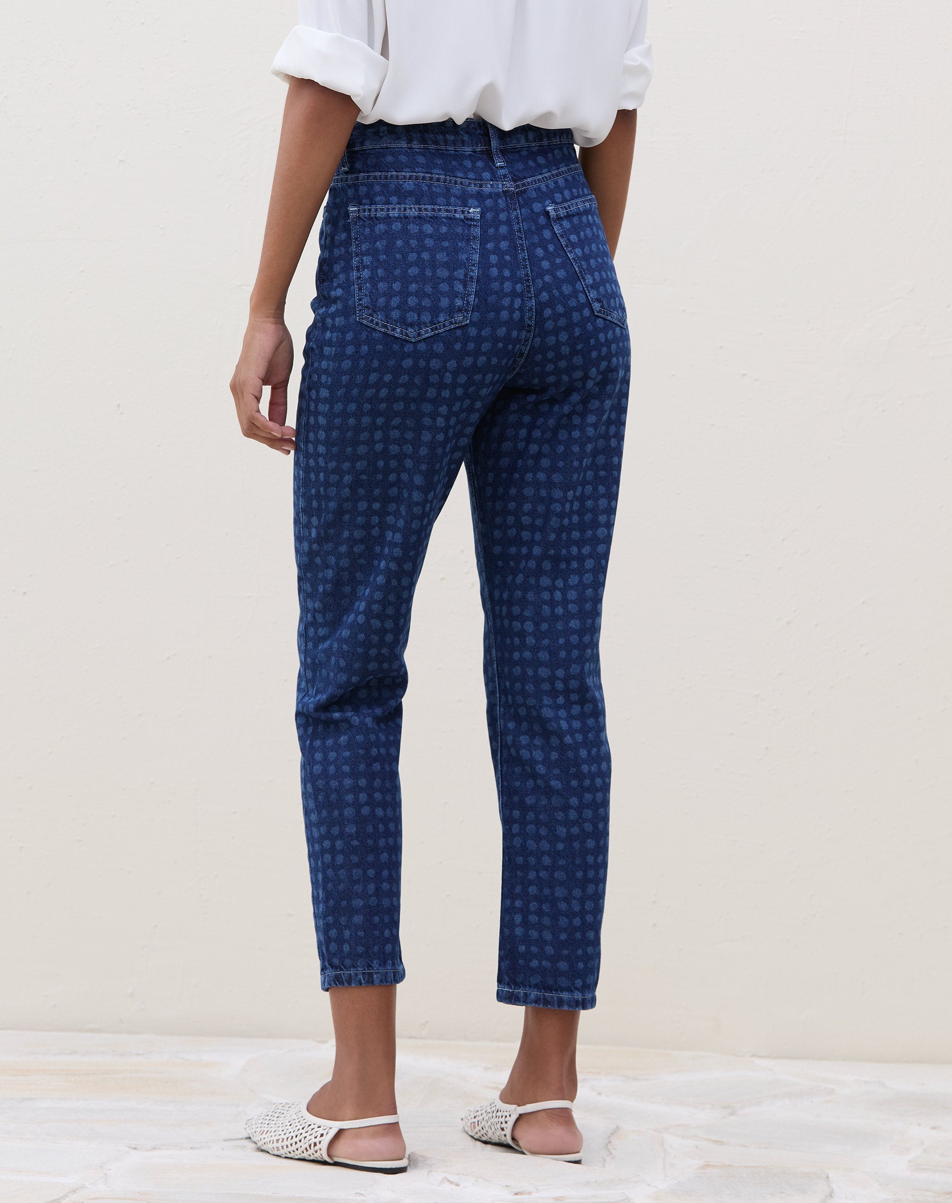 Vista traseira da calça Mom Jeans azul médio com estampa de bolinhas.