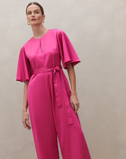 Macacão rosa escuro com mangas sino e cinto, vista frontal.