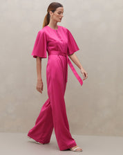 Macacão rosa escuro com mangas sino e cinto, vista lateral.