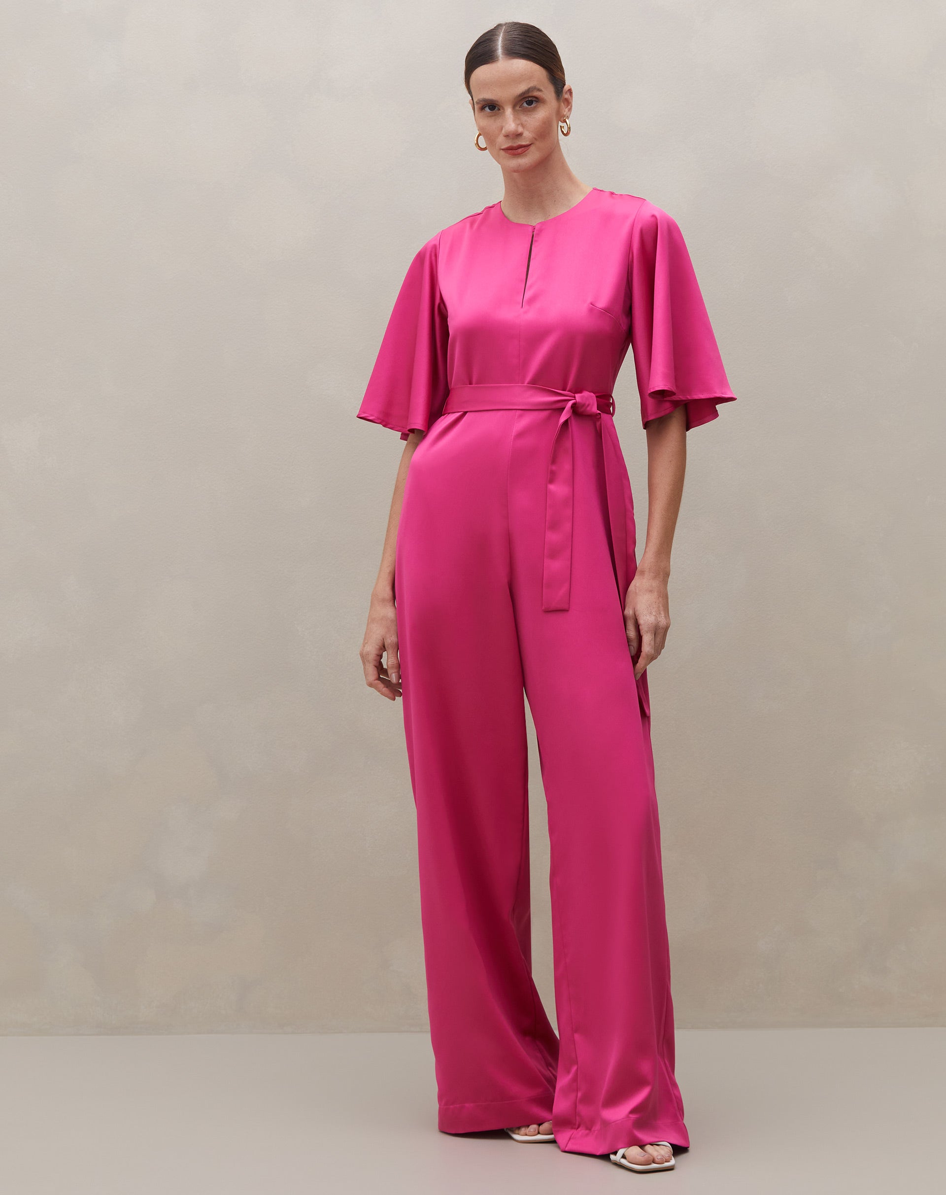 Macacão rosa escuro com mangas sino e cinto, vista completa.