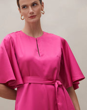 Detalhe do decote redondo do macacão rosa escuro.