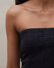 Detalhe do tecido jeans preto do top sem alça, destacando sua textura.