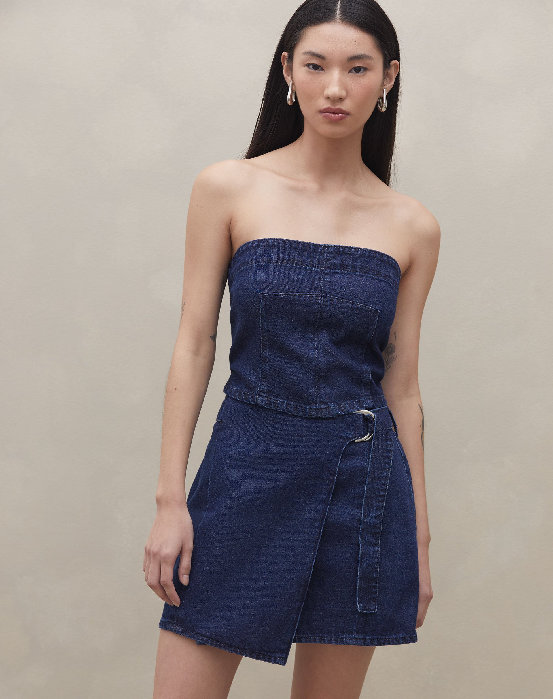Top sem alça jeans azul escuro visto de frente, destacando seu design ajustado.