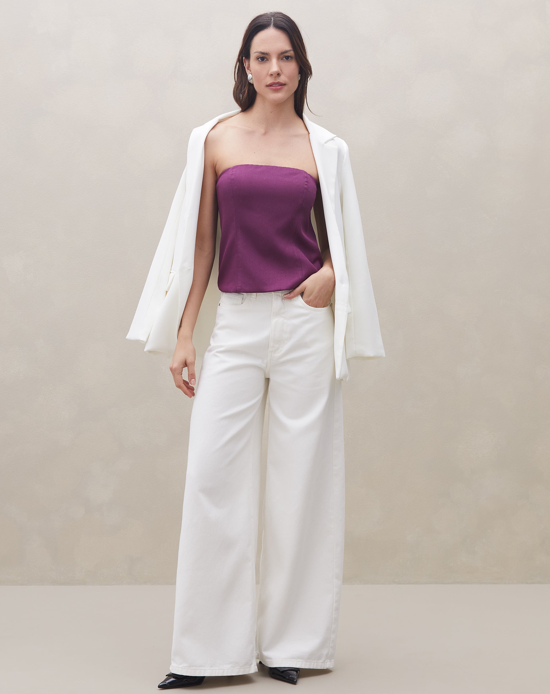 Modelo usando a blusa sem alça roxa com calça branca e blazer, criando um look sofisticado.