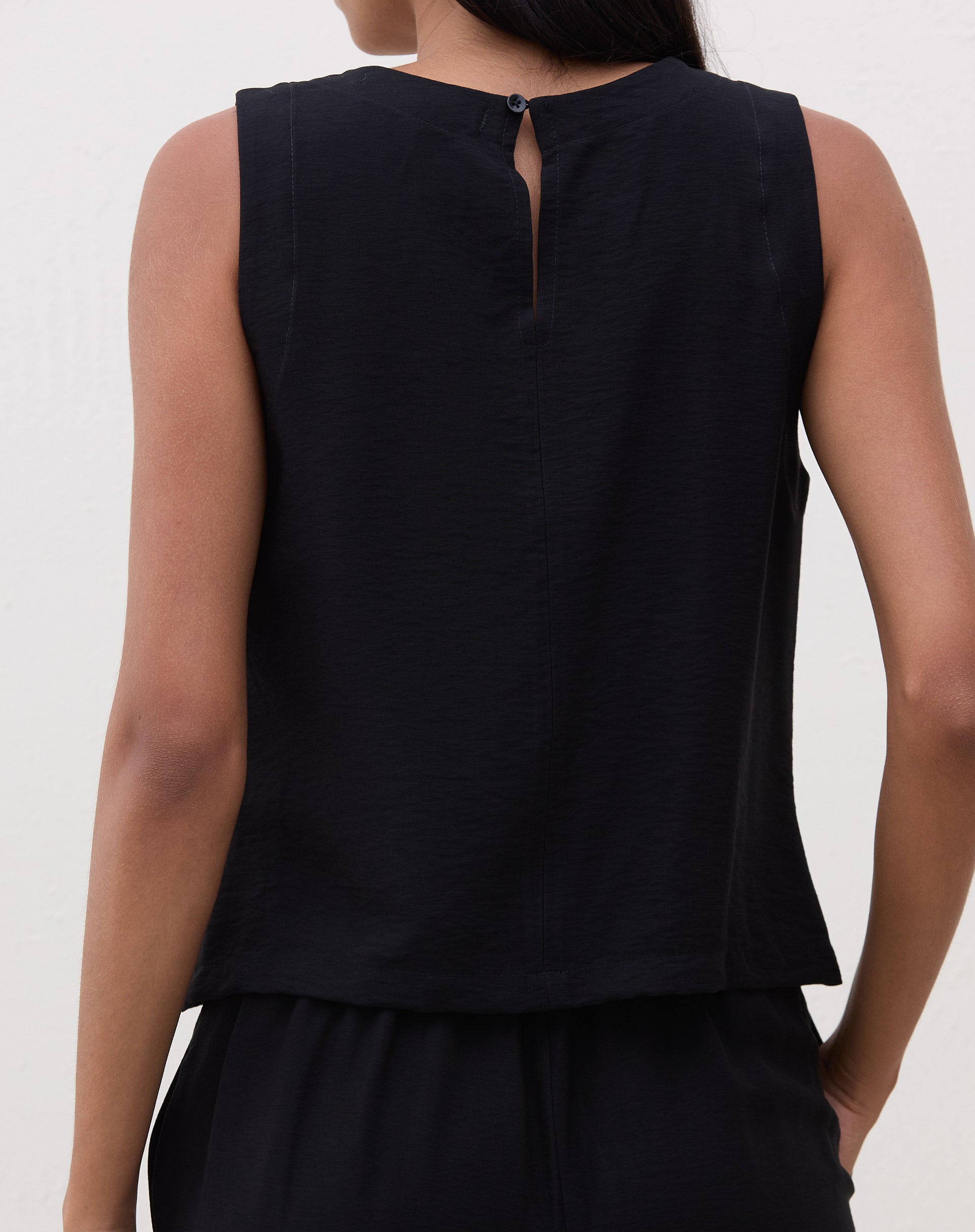 Regata reta preta em crepe, vista traseira com fecho de botão.