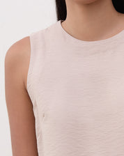 Detalhe do decote redondo da regata reta bege.