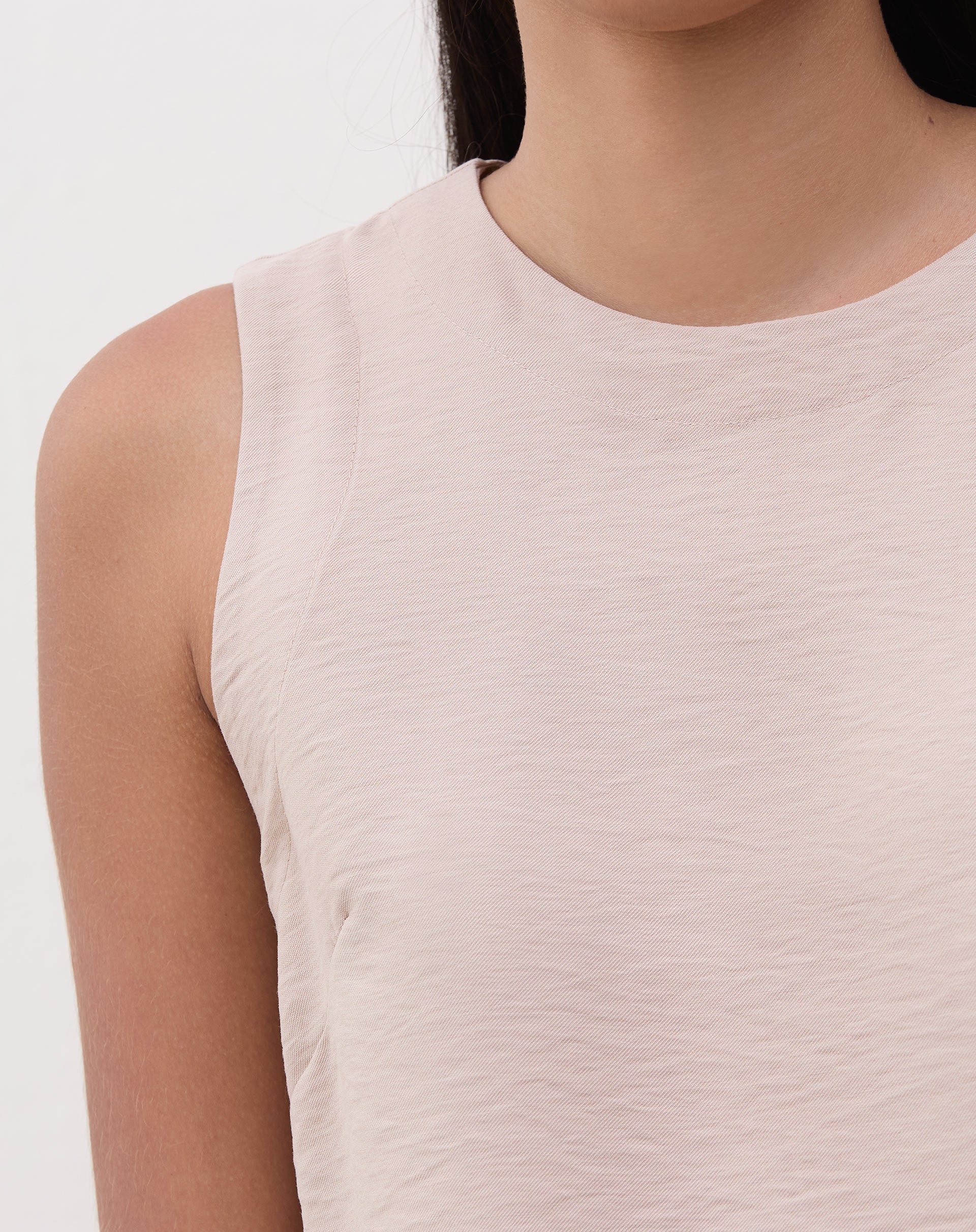 Detalhe do decote redondo da regata reta bege.