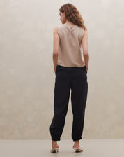 Regata reta bege combinada com calça preta, vista traseira.