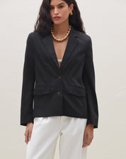 Blazer preto slim com abotoamento simples, visto de frente.