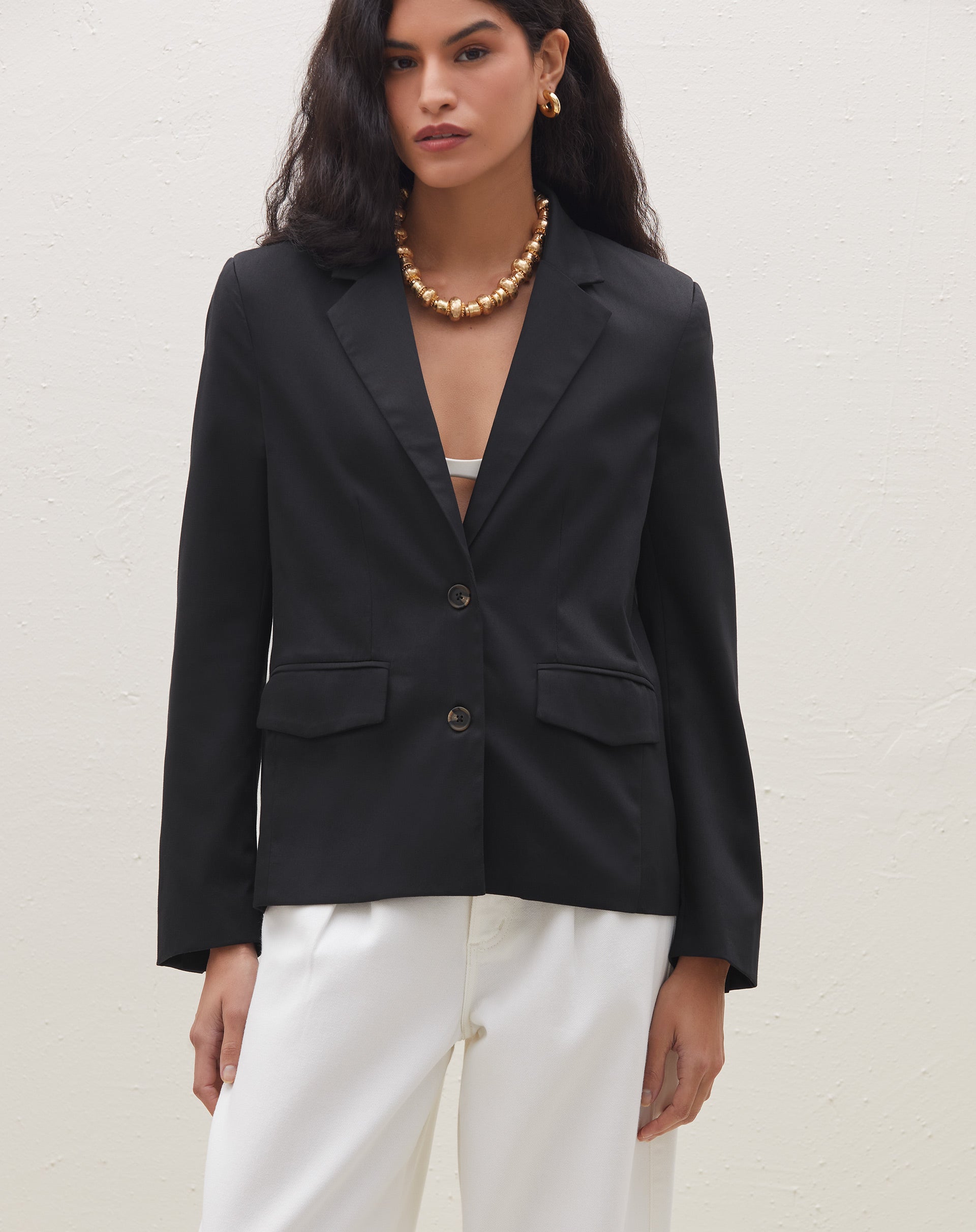 Blazer preto slim com abotoamento simples, visto de frente.