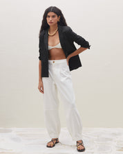 Blazer preto slim com abotoamento simples, estilo casual com mangas dobradas.
