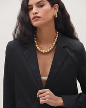Detalhe da lapela e abotoamento do blazer preto slim.