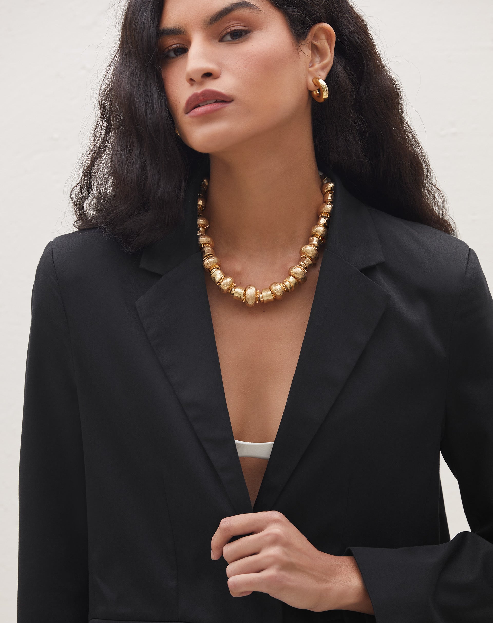 Detalhe da lapela e abotoamento do blazer preto slim.