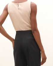 Vista traseira detalhada da calça de alfaiataria baggy preta com pregas.