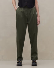 Detalhe da calça baggy verde escuro com pregas e cintura alta.