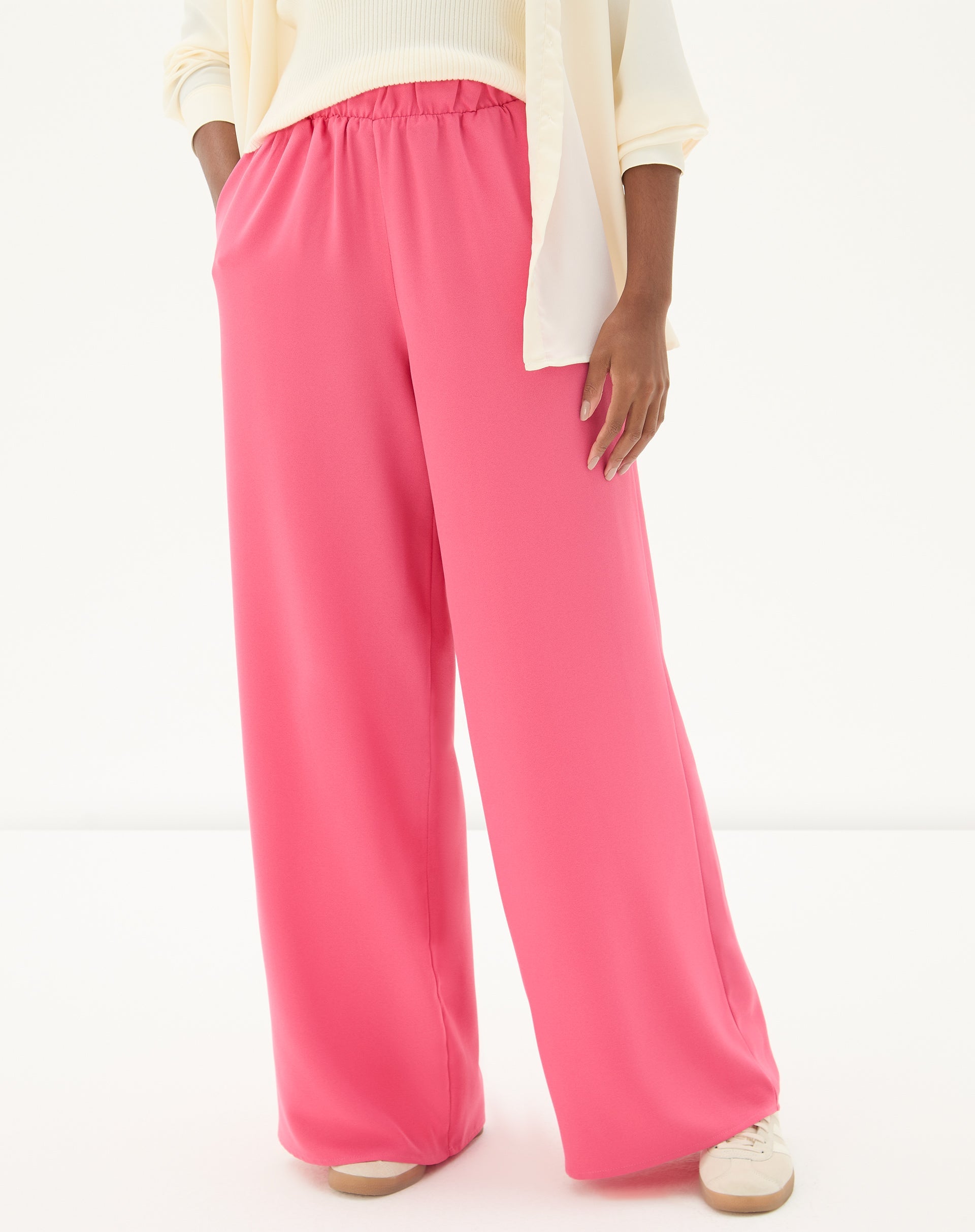 Vista frontal da calça wide leg coral com pregas.