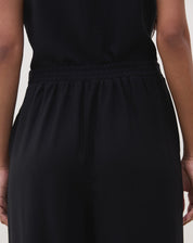 Vista traseira da calça preta reta com cós elástico.