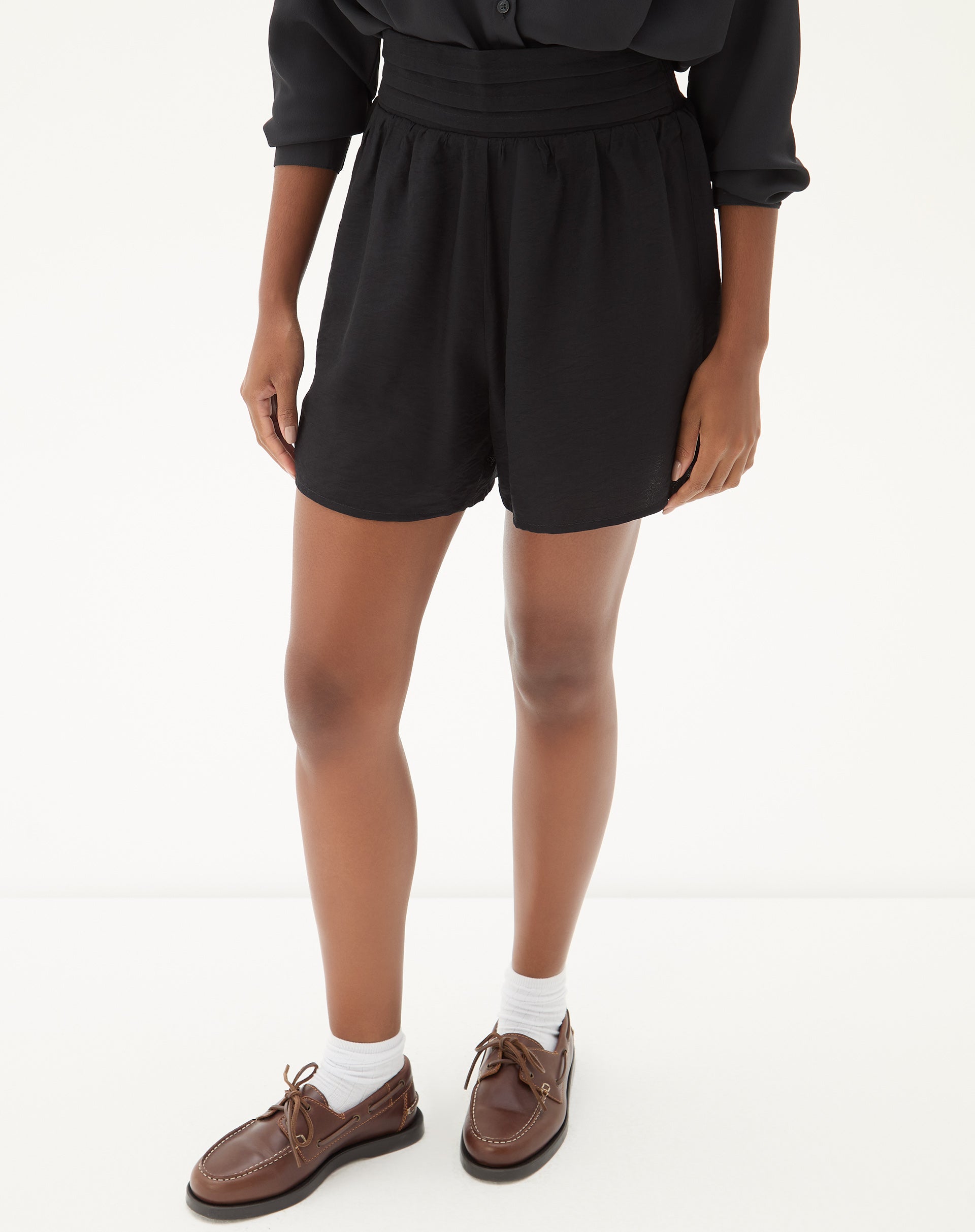 Vista lateral do shorts preto mostrando o ajuste na cintura.