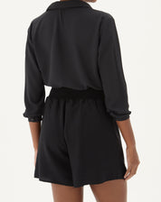 Vista traseira do shorts preto com cós elástico.