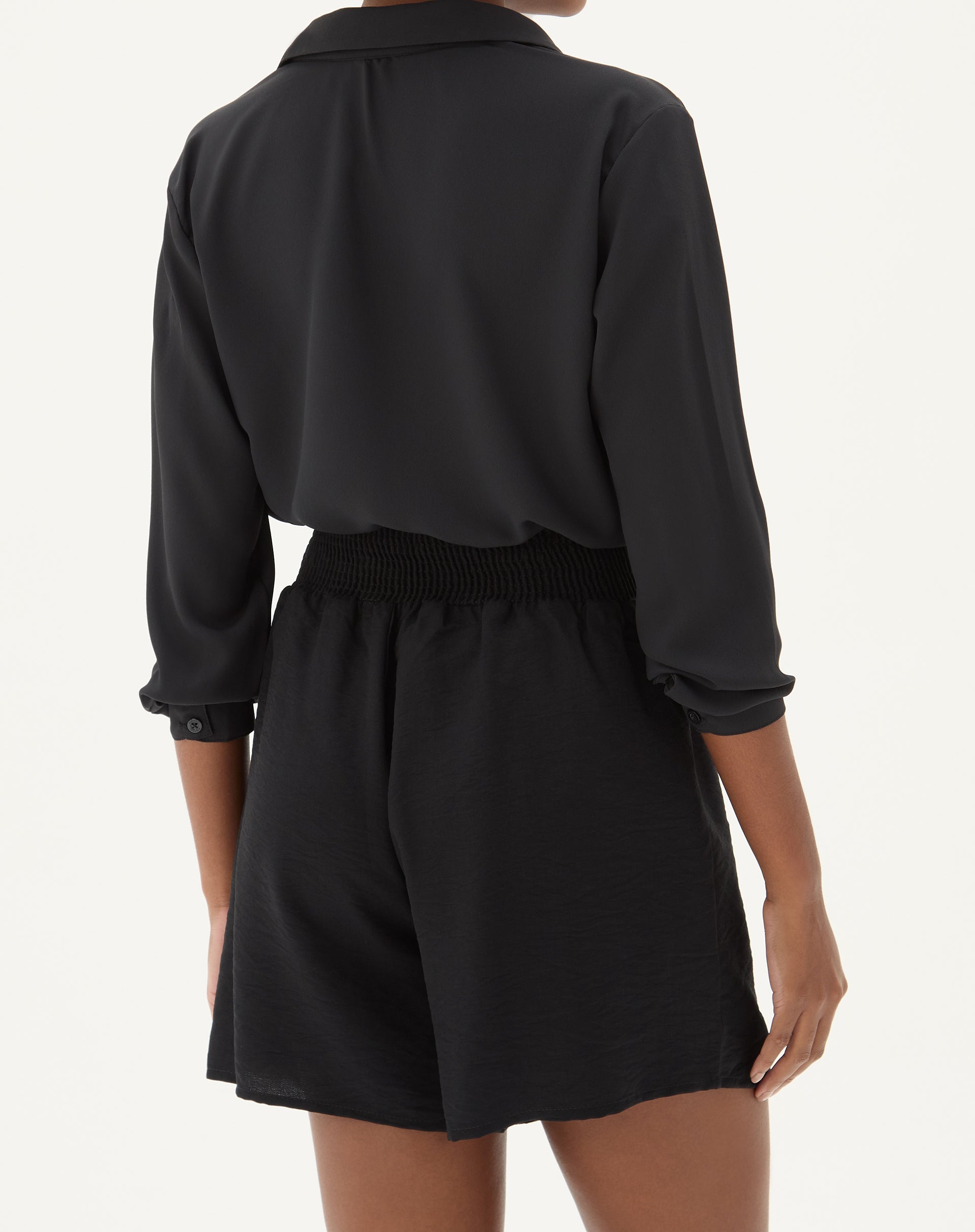 Vista traseira do shorts preto com cós elástico.