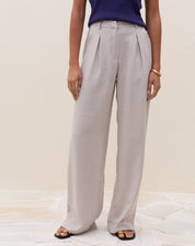 Vista frontal da calça cinza claro com cintura alta e pregas.